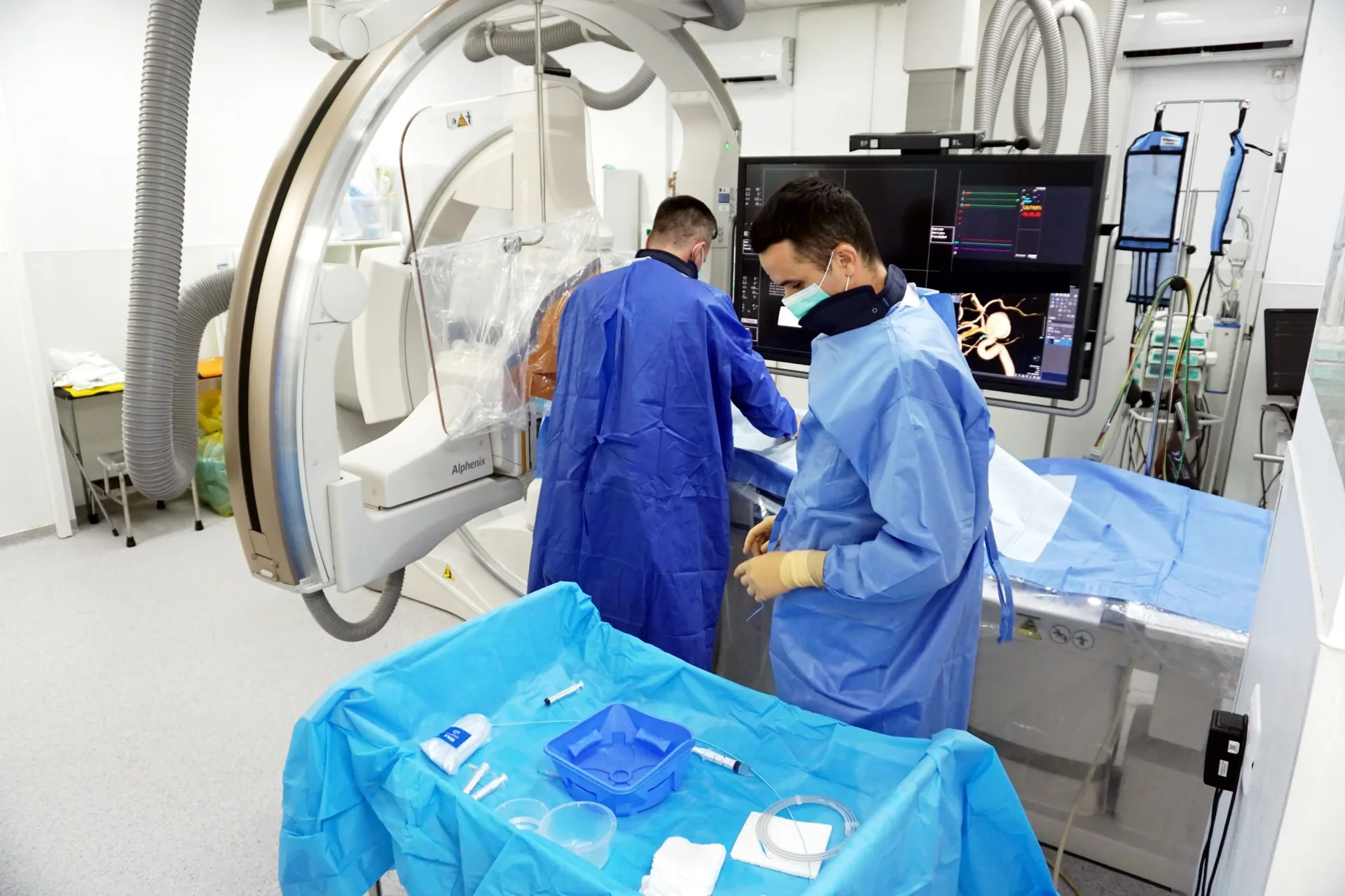 Echipă medicală INNBN în timpul unei intervenții neurovasculare, cu reconstrucție 3D a vaselor cerebrale pe monitor